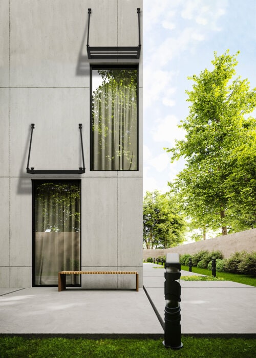 Modern concrete building with black metal canopies over the windows